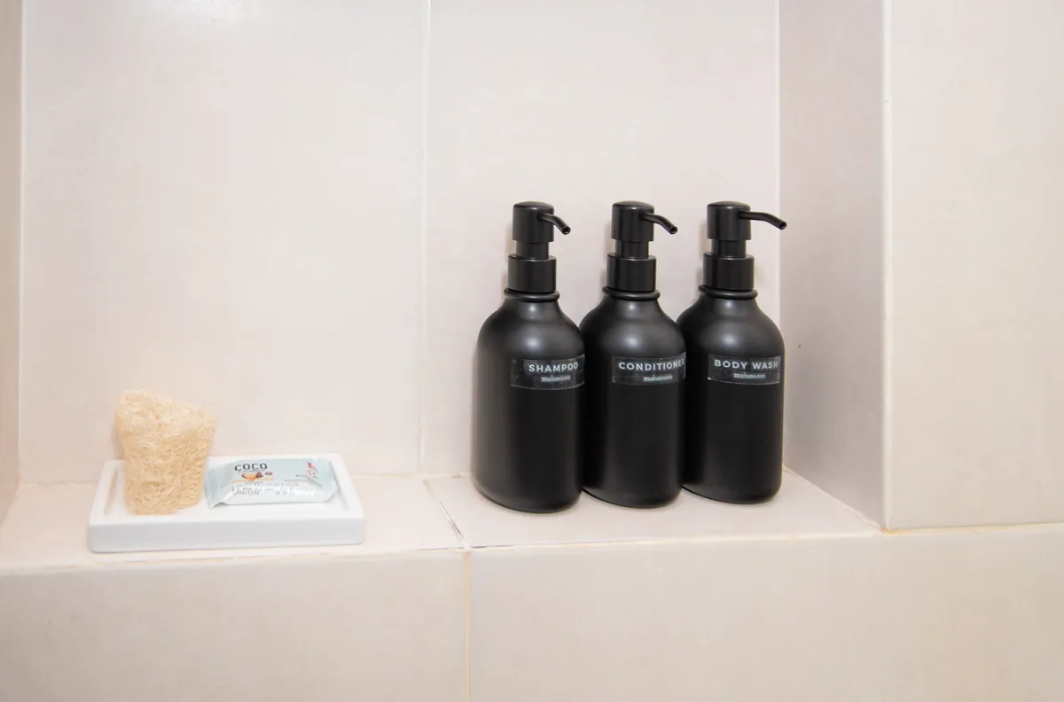 Shampoo, acondicionador y jabón líquido en la ducha