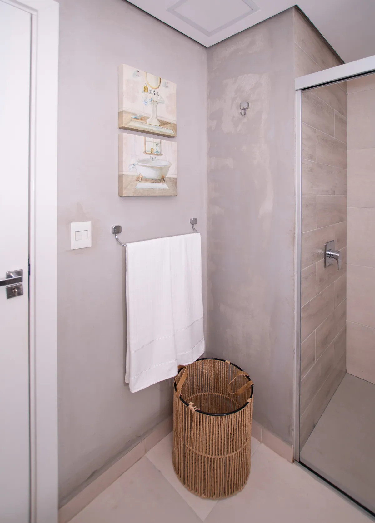 La ducha, con toalla y cesto de ropa