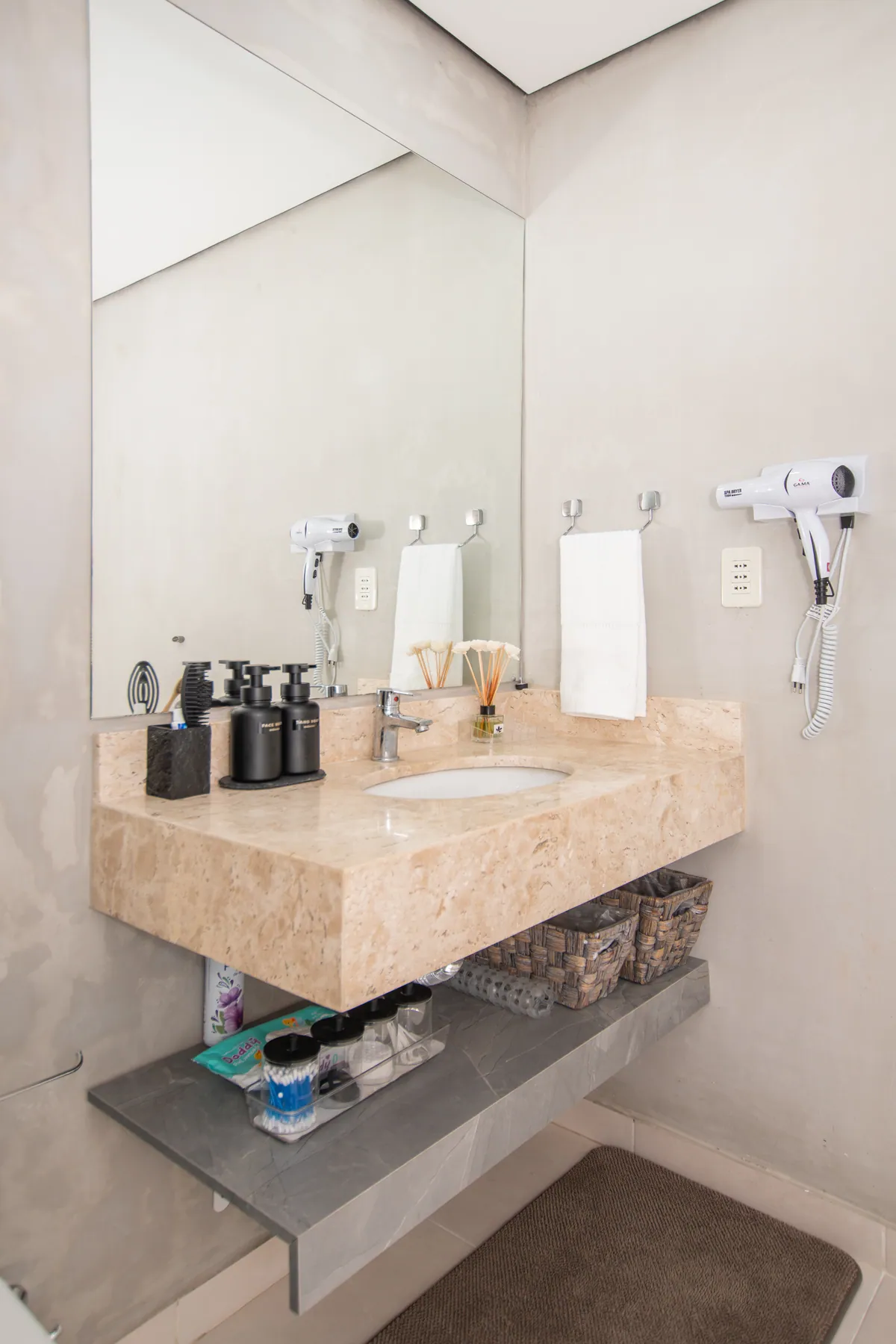 La pileta del baño con secador de pelo y toallas